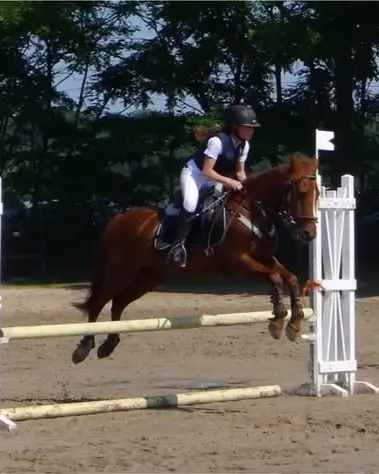 Maya à cheval, franchissant un obstacle en concours
